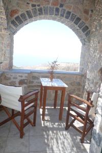 AvgonymaにあるTo Asteriのテーブルと椅子2脚、窓が備わる客室です。
