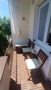 balkon z 3 krzesłami i oknem w obiekcie Moon Tree *** w mieście Varaždin