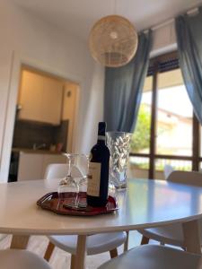 馬帝斯茲羅的住宿－Appartamento vacanze al mare，桌子上放一瓶葡萄酒和玻璃杯