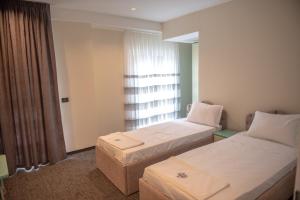 斯特鲁加Hotel Roma的有两张床和一扇窗户的酒店房间