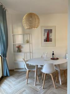 una sala da pranzo con tavolo e sedie bianchi di Appartamento vacanze al mare a Martinsicuro