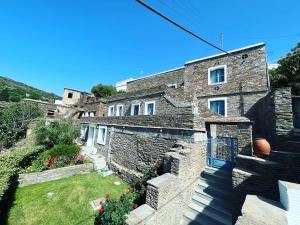 an old stone house with a garden in front of it at Petra Traditional House in Episkopión
