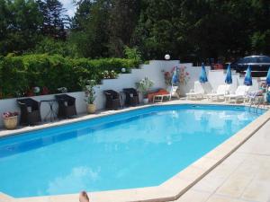 a large blue swimming pool with chairs at Апартамент Холи in Sozopol