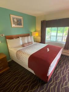 ein großes Bett in einem Hotelzimmer mit Fenster in der Unterkunft Cozy Corner Motel in Williamstown