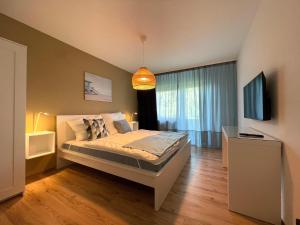 1 dormitorio con 1 cama, TV y lámpara de araña en Cityapartment SB Am Homburg, en Saarbrücken