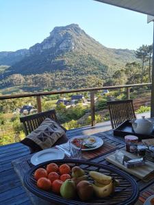 a table with fruit on it with a view of a mountain at Berghuesli Villa de Luxe in Cape Town