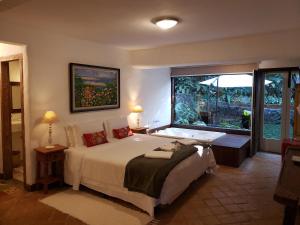 a bedroom with a bed and a large window at A Arte de Bem Viver in Tiradentes