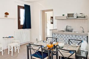 a kitchen with a table and chairs and a sink at Residence San Martino- Rooms & Suite Apartments in Erice