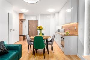 ein kleines Apartment mit einem Tisch und Stühlen sowie einer Küche in der Unterkunft Star4You II Apartments in Breslau