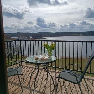 una mesa y sillas en un balcón con vistas al agua en Apartament z widokiem Azyl Widoki, en Wielkie Leżno