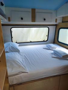 a bed in the back of a boat with a window at Hostel Trobenta in Oblak in Portorož