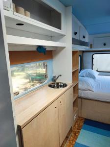 a kitchen in an rv with a sink and a bed at Hostel Trobenta in Oblak in Portorož
