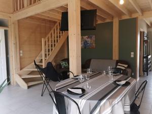 a dining room with a table with chairs and a staircase at Gîtes ETCHE ARGUINIA in Montory