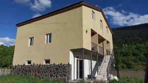 un grande edificio con una recinzione intorno di STOP HOUSE Mestia a Mestia