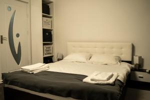 a bedroom with a bed with two towels on it at Studio Six Continents in Petroşani