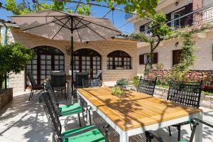 una mesa de madera y sillas con sombrilla en Apartments Paloc - Blue, en Bol