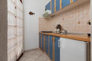 Una cocina con gabinetes azules y un fregadero. en Apartments Paloc - Blue, en Bol