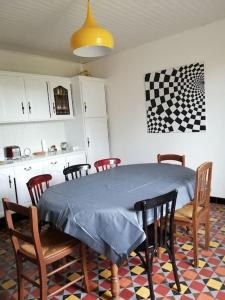 uma sala de jantar com mesa e cadeiras e uma cozinha em La Case à Jane, gite familial en pays tarnais em Coufouleux