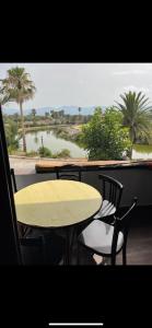 a yellow table and chairs with a view of a river at Bahia Smir in Restinga Smir