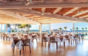 um salão de banquetes com mesas e cadeiras e a praia em V4 Zona Verde em Isola Albarella