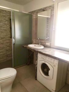 uma casa de banho com uma máquina de lavar roupa e um lavatório em Sabrina em Rosolina Mare