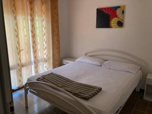 a white bed in a bedroom with a picture on the wall at Sabrina in Rosolina Mare