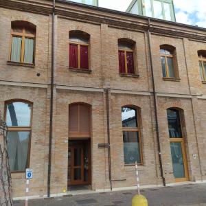 ラヴェンナにあるaffittacamere Corte Callegariの通りに多くの窓があるレンガ造りの建物