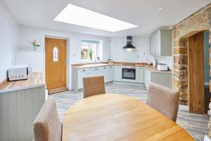a kitchen with a wooden table and chairs at Poets Cottage in Skinningrove