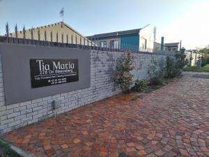 un cartel en una pared de ladrillo junto a una acera de ladrillo en Tia Maria House, en Ciudad del Cabo 2 fotos más