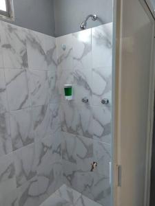 bagno con doccia e piastrelle in marmo bianco di Apartamento 2 recamaras en el corazón de Cozumel a Cozumel