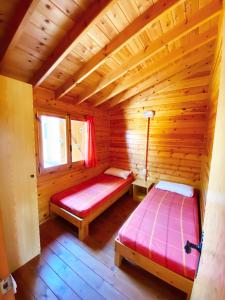 a room with two beds in a wooden cabin at Bungalows Camping Ferrer in Peniscola