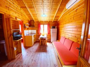 a living room with a red couch in a wooden house at Bungalows Camping Ferrer in Peniscola