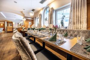 una mesa larga en un restaurante con sillas en Schlosshotel Lacknerhof, en Flachau