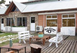 a patio with two chairs and a table and a building at Hostel Bahía Ballenas in Puerto Pirámides