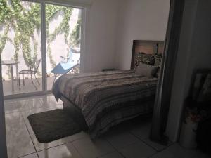una camera con letto e vista su un patio di Casa bonita a dos cuadras del mar a Playa del Carmen