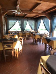 a restaurant with wooden tables and chairs and windows at Agriturismo Antiglia in Sovana
