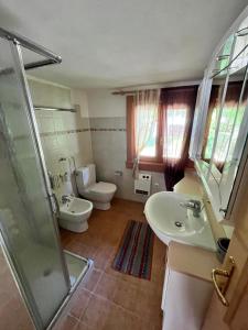 uma casa de banho com um WC, um lavatório e um chuveiro em Trentino Val Rendena casa con vista 3 camere doppie e 2 bagni em Groppe de Fora