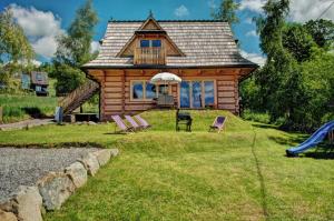 une cabane en rondins avec un toboggan et une aire de jeux dans l'établissement Drewniany Dom Góralski Kierpcówka 4a, à Kościelisko