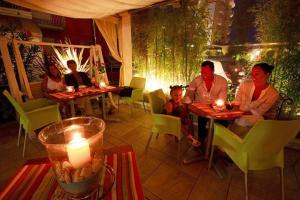 a group of people sitting at tables in a restaurant at Hotel Jet in Lido di Jesolo