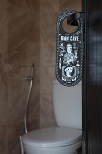 um sinal de caverna de homem ao lado de um WC em uma casa de banho em Top view hostel em Durrës
