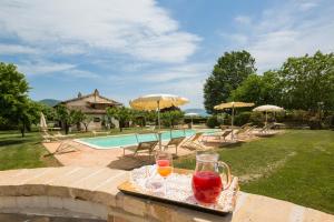 a tray with drinks on a table next to a pool at Agriturismo Il Barco in Spello