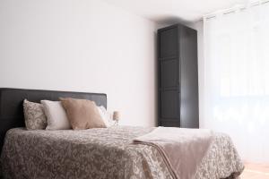 - une chambre avec un grand lit et une tête de lit noire dans l'établissement Precioso piso en el centro de Moaña, à Moaña