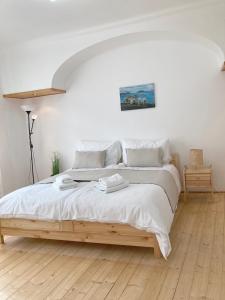 a bedroom with a large bed with white sheets at Three Rings Apartments in Karlovy Vary