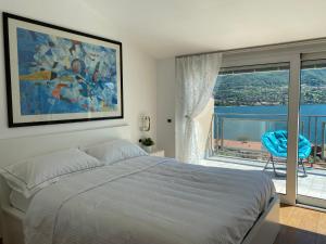 1 dormitorio con cama y ventana grande en Le Terrazze sul Lago di Como, en Oliveto Lario