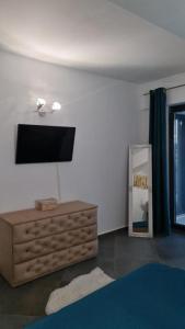 a living room with a television on a wall at Apartament FIORE BLU ( vedere la mare si lac) in Năvodari