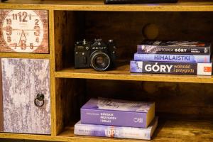 a book shelf with a camera and some books at Apartament Kierunek Tatry in Bukowina Tatrzańska