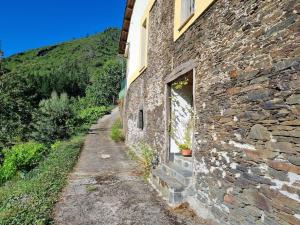 una casa de piedra con un camino de piedra junto a un edificio en Casa Satya, 