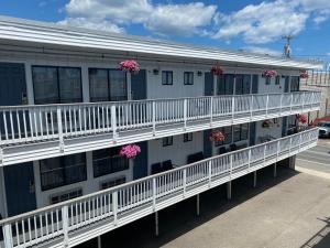 an apartment building with white balconies and pink flowers at Ways Motel in Hampton