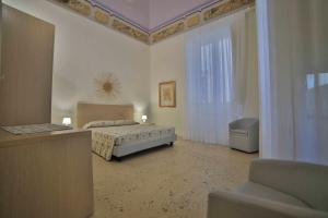 a bedroom with a bed and a chair in a room at Palazzo Zacheo in Gallipoli