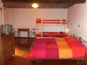 - une chambre avec un lit doté d'un couvre-lit coloré dans l'établissement AGRITURISMO IL RUNCH DI MAJRANO LUCA, à Viù